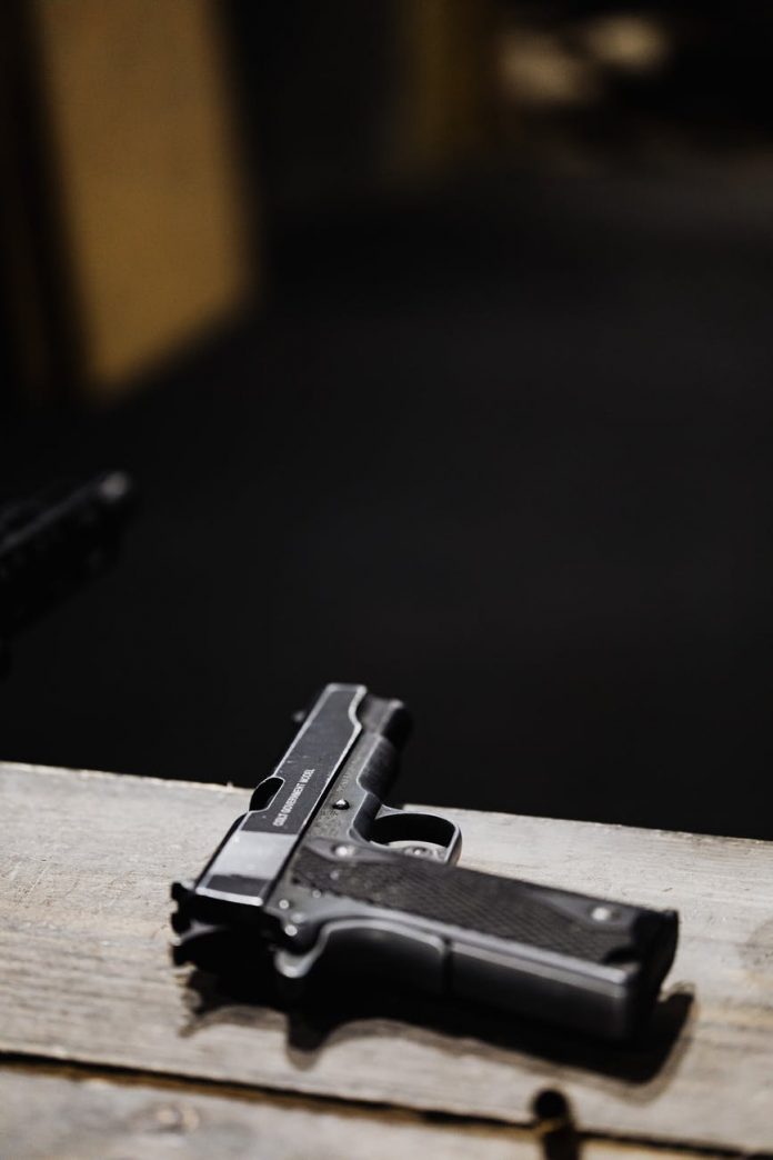pexels-photo-5202433 black semi automatic pistol on brown wooden table